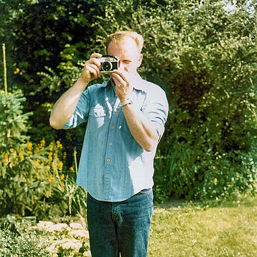 En mand fotograferer med analog kamera